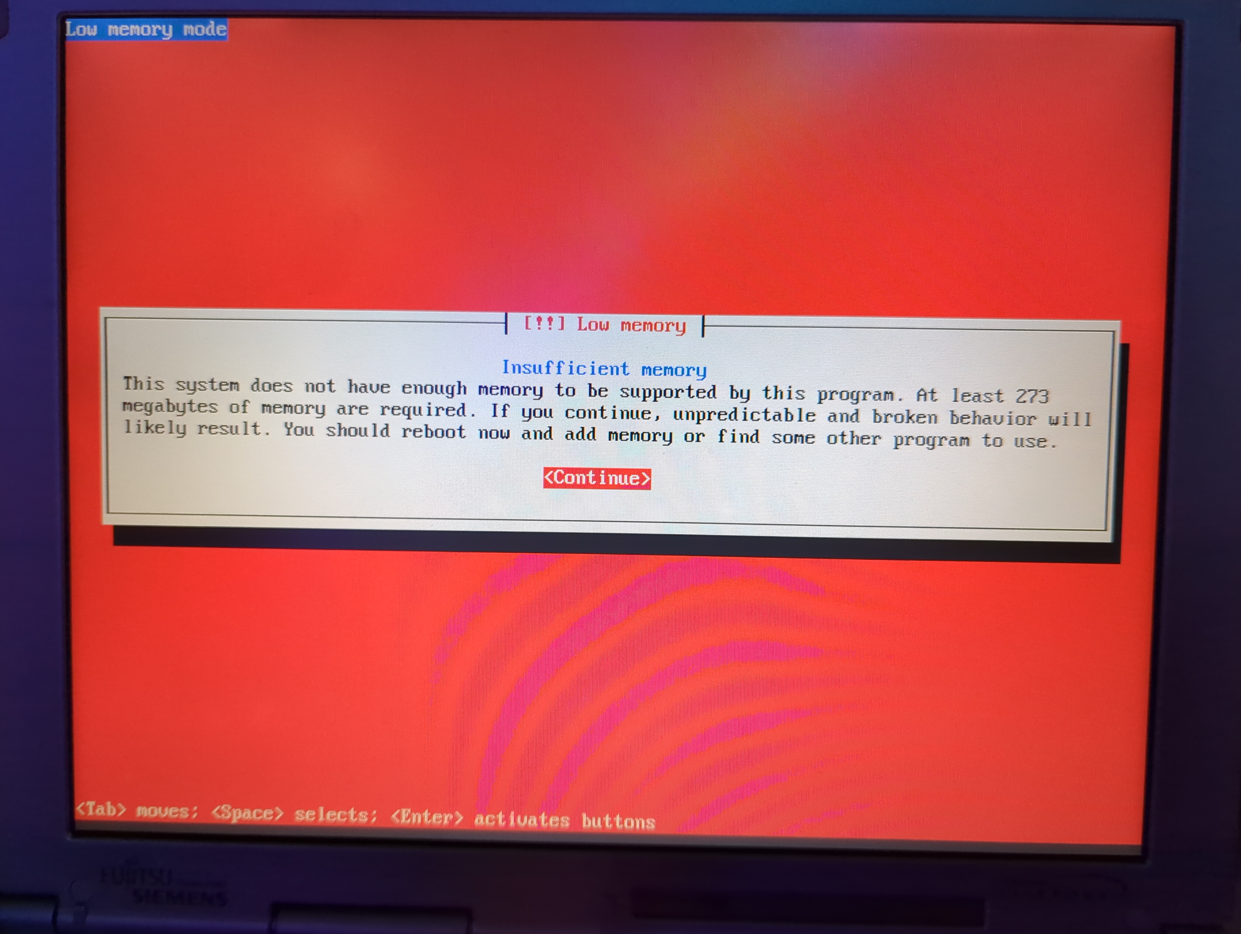Picture of the Debian setup assistant. The top left reads “Low memory mode”. The center of the screen reads “[!!] Low memory\nInsufficient memory\nThis system does not have enough memory to be supported by this program. At least 273 megabytes of memory are required. If you continue, unpredictable and broken behavior will likely result. You should reboot now and add memory or find some other program to use.\n<Continue>”